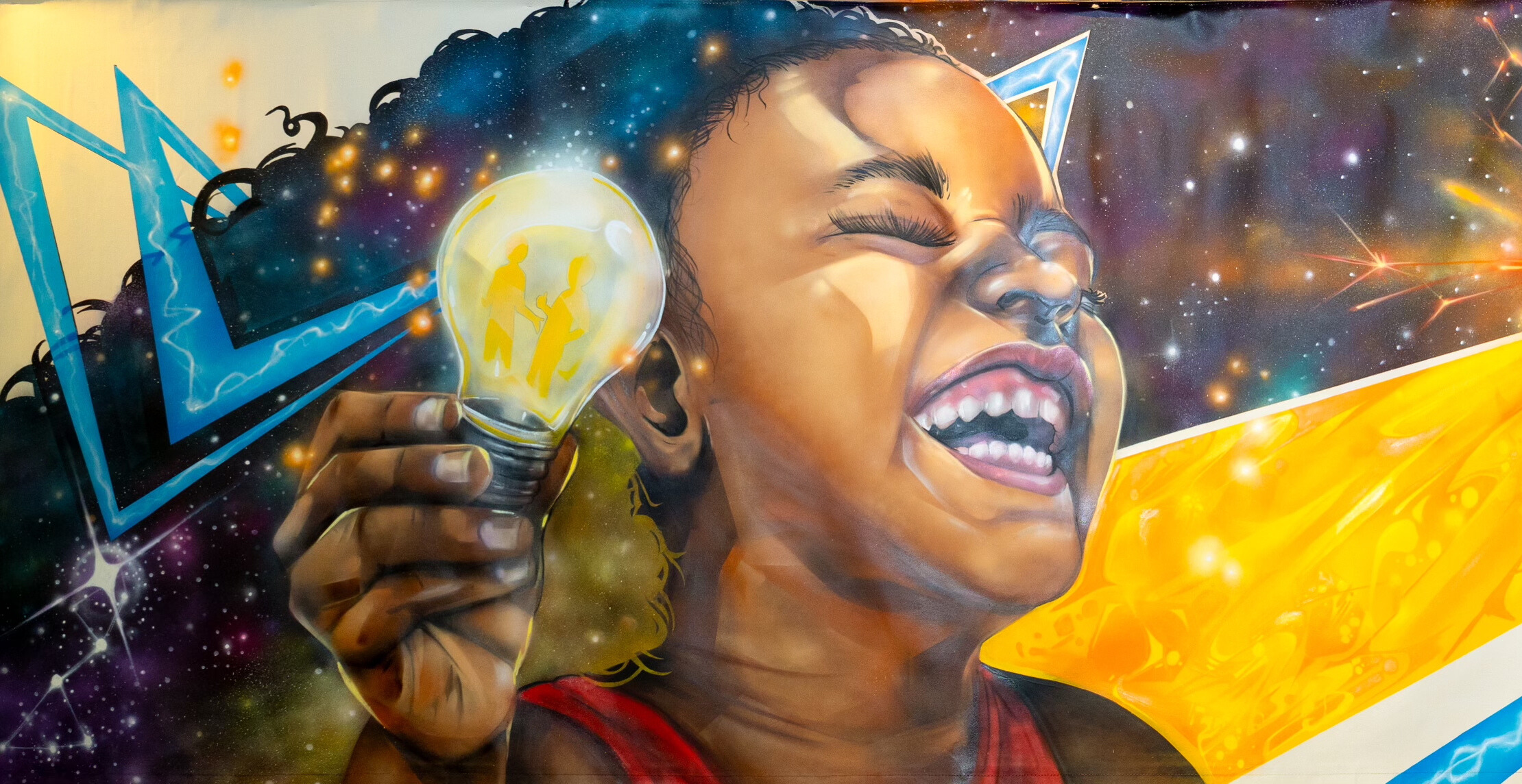 A vibrant mural of a joyful child laughing and holding a glowing light bulb, with silhouettes of two people inside it. The colorful background features stars and abstract shapes, conveying creativity and inspiration.
