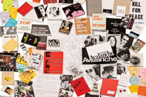A colorful, scattered assortment of vintage magazines, art books, zines, flyers, and pamphlets, featuring bold text, black-and-white photos, and graphic designs on various topics, spread across a white background.